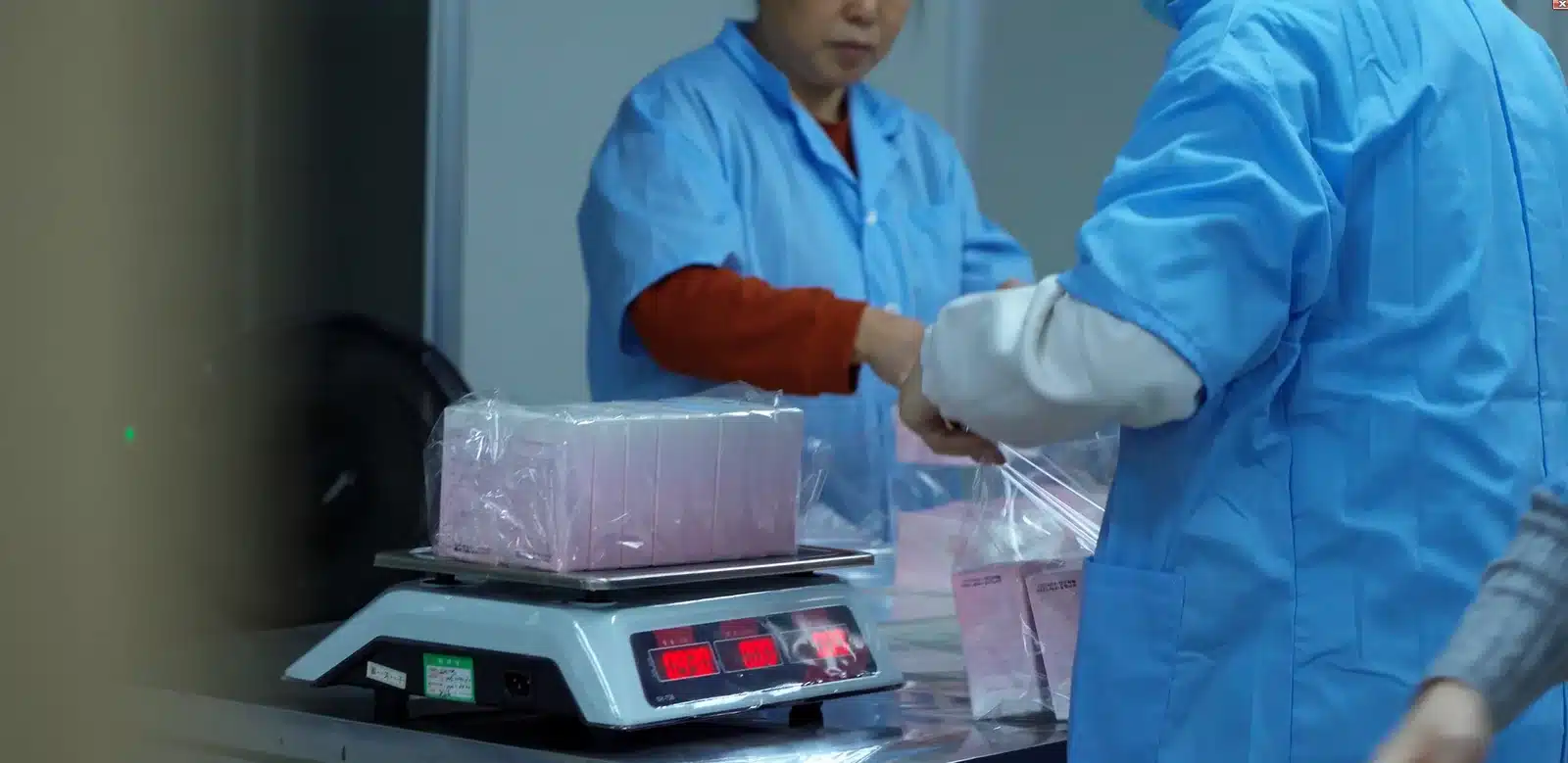 Packaged cosmetic units being weighed and reconciled by batch at a supplier facility in Guangzhou