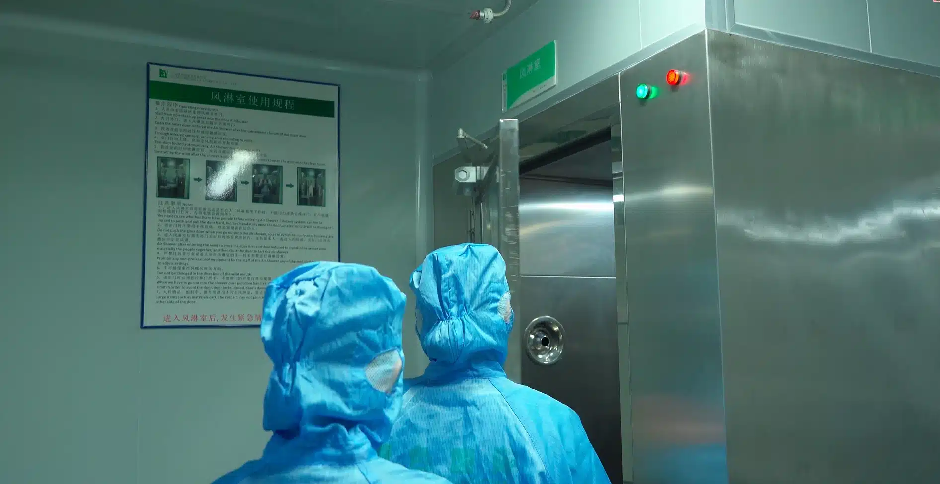 Cleanroom workers following an air shower entry procedure in a cosmetics factory