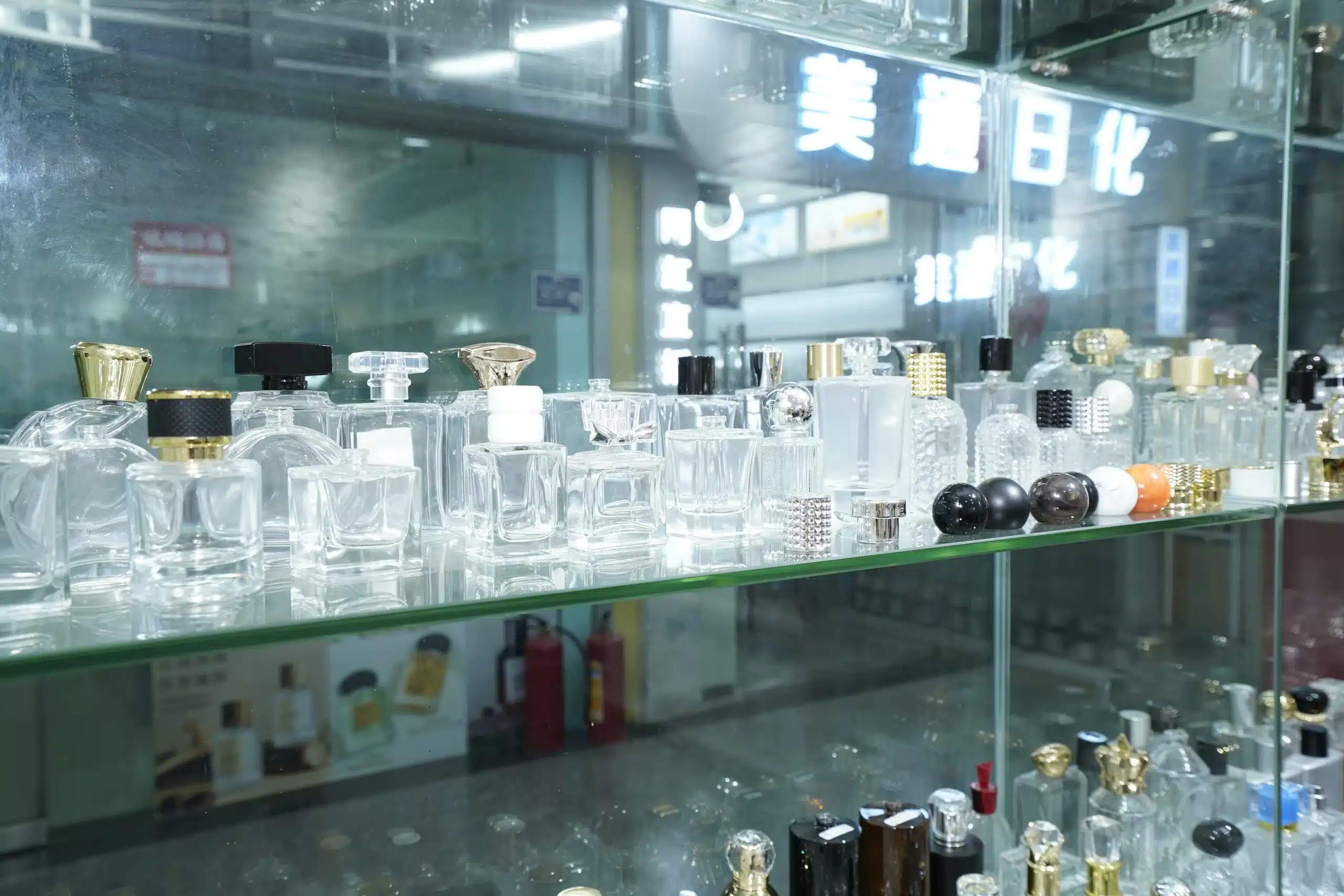Clear glass bottles with different shapes and cap designs on a showroom shelf
