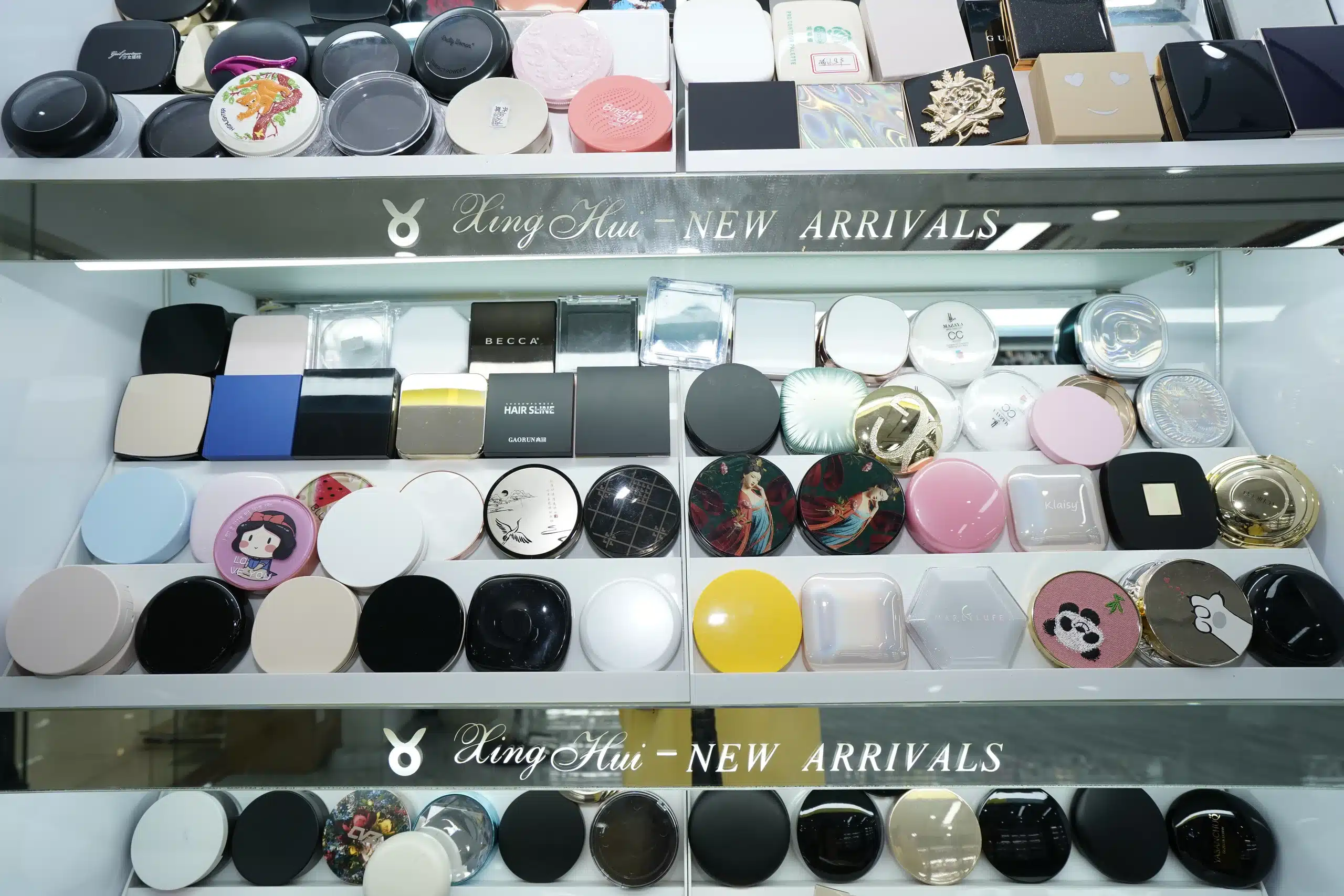 Round and square cosmetic compact cases in assorted colours and surface finishes